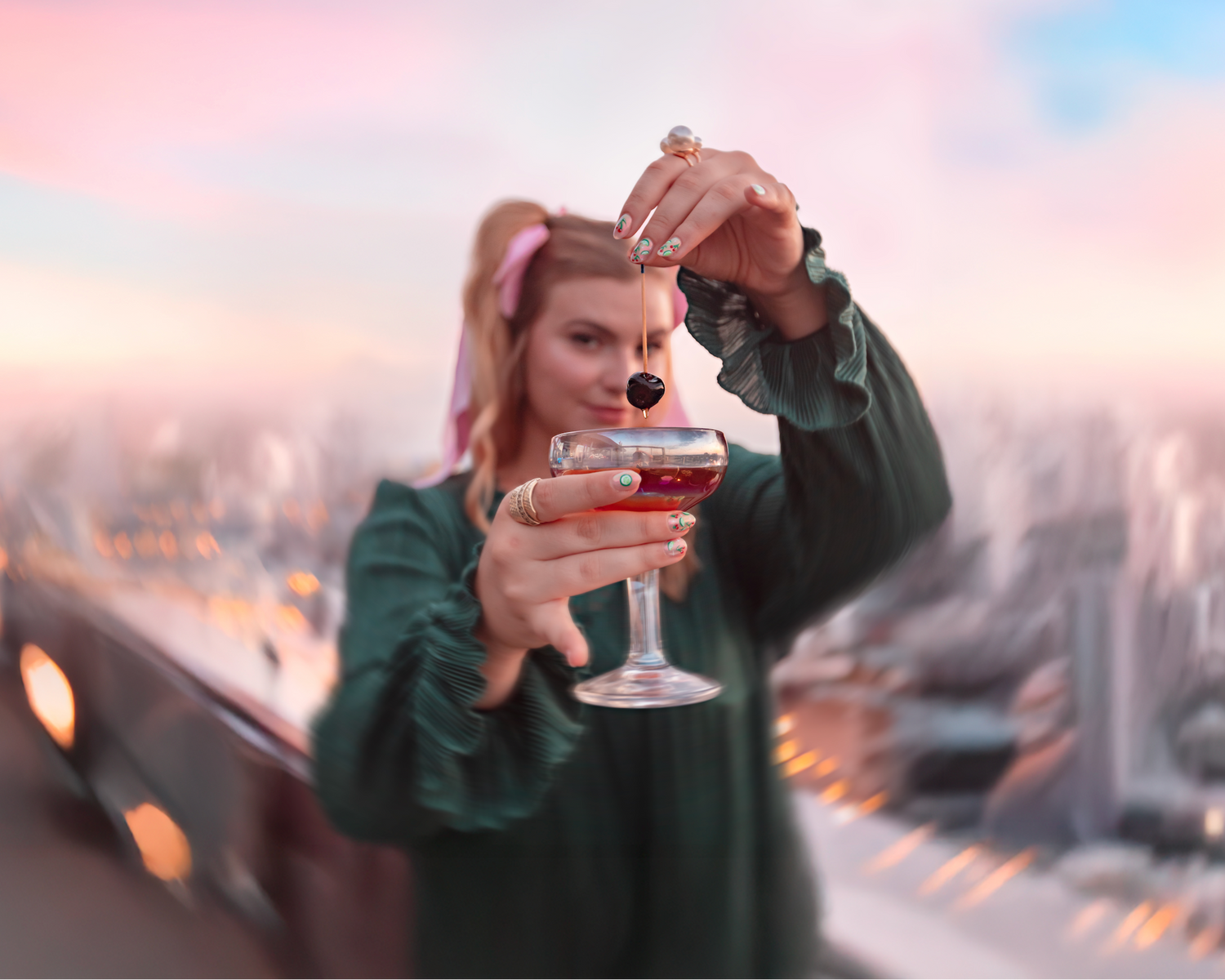 Nancy holding a glass with a cityscape in the background